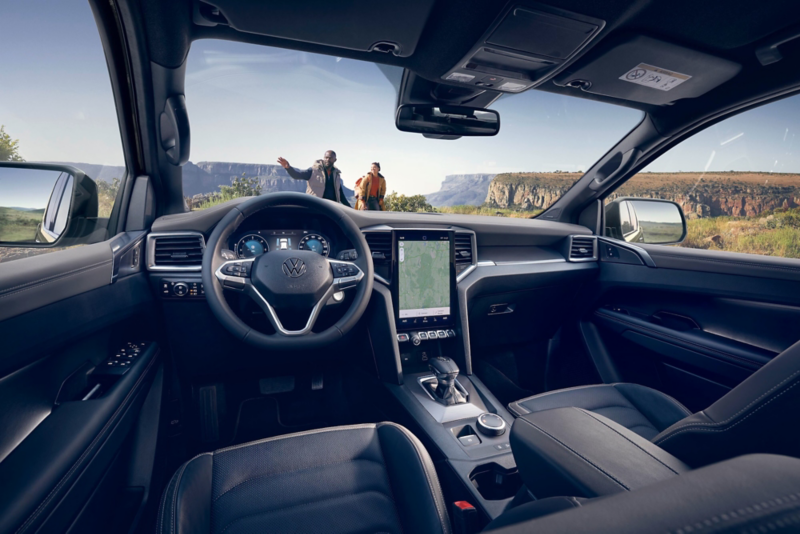 El VW Nuevo California aparcado en la orilla junto a dos personas.