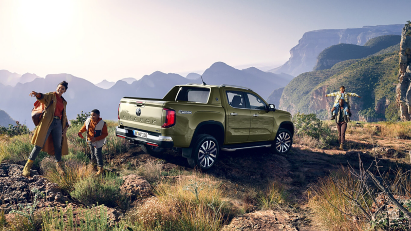 Een gezin heeft de VW Amarok langs een verharde weg geparkeerd.