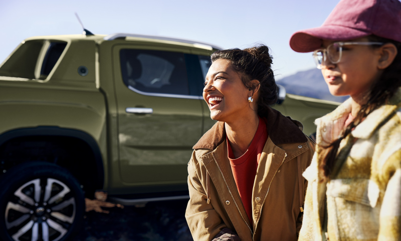 Zwei Frauen stehen neben einem geparkten VW Amarok in der Natur.