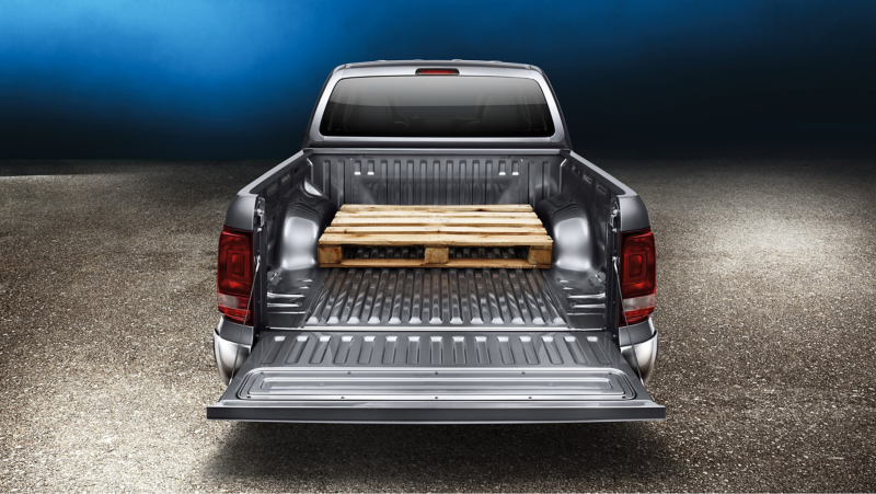 the back of an Amarok with the tailgate folded down showing a crate loaded in the back