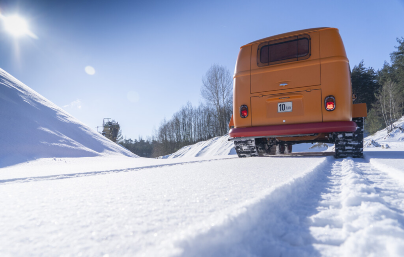 Eine Rückansicht vom VW T1 Raupenfuchs der eine Raupenspur im Schnee hinterlässt.