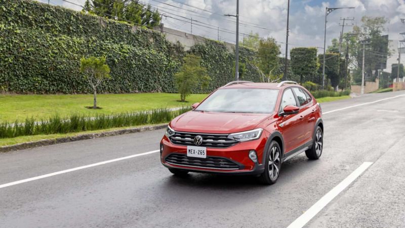 Volkswagen Nivus 2024 transita en una calle con jardines. 