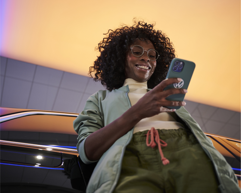 Woman using myVW app to control VW vehicle.