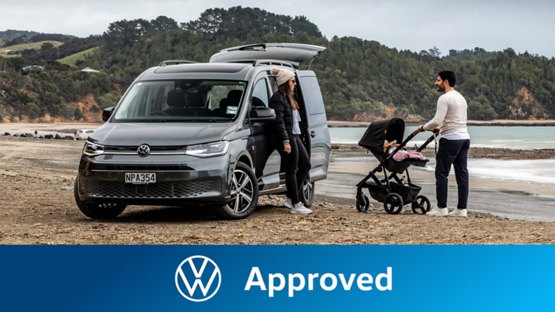 Una familia con su furgoneta Volkswagen Approved en la playa