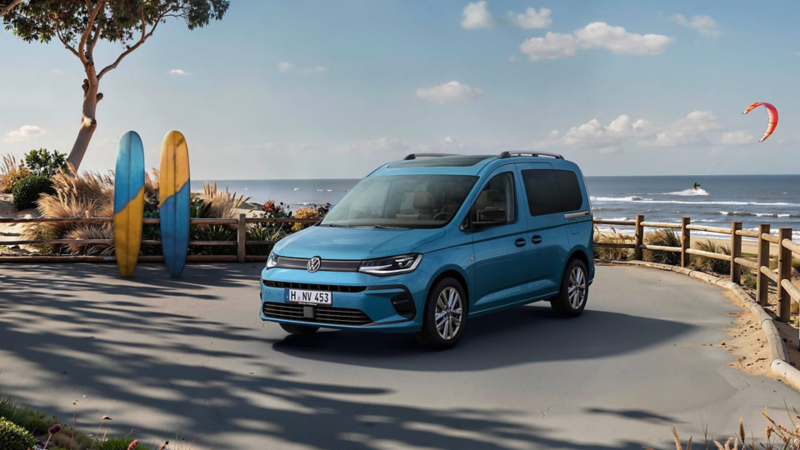 Una furgoneta Volkswagen de ocasión aparcada en un ambiente natural con el mar de fondo y unas tablas de surf a su izquierda