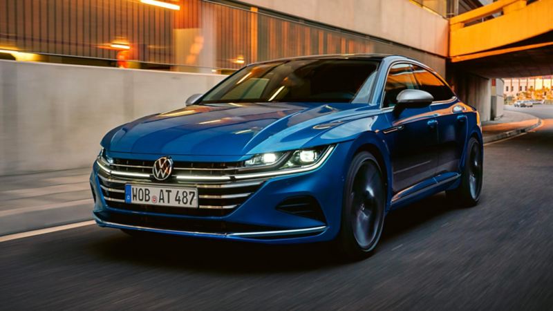 VW Arteon bleue en circulation avec les phares allumés