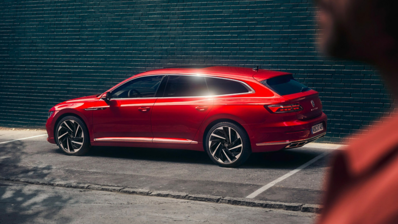 VW Arteon shooting brake rouge de profil garée sur une place de parking