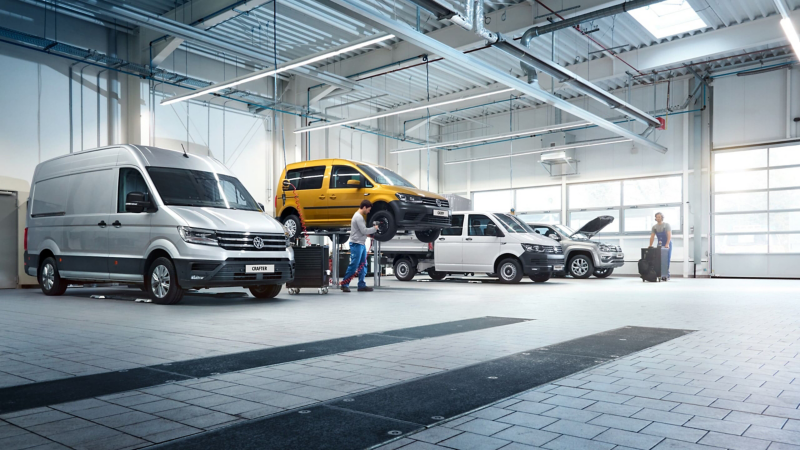Dostawcze Volkswageny stoją na stanowiskach w serwisie.