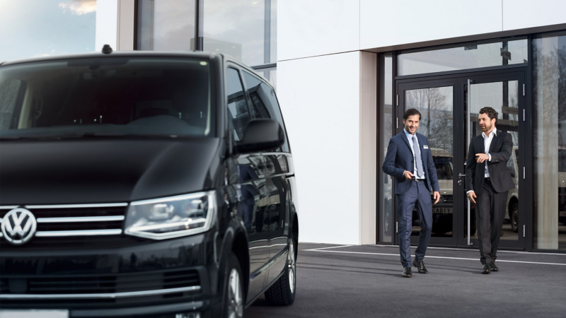 Dwaj mężyczyźni idą do samochodu Volkswagen.