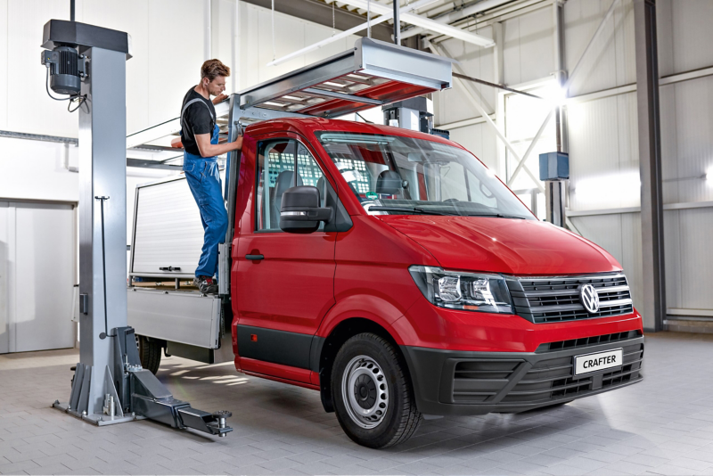 Mechanik montuje drabinę do Volkswagen Crafter Skrzyniowy.