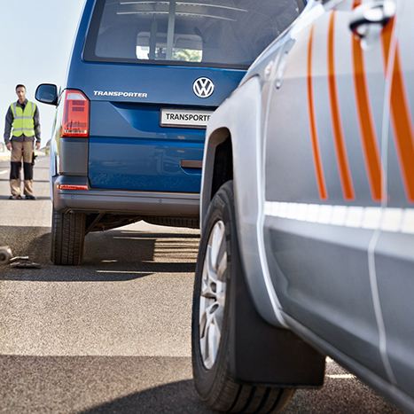 Dwóch mężczyzn stoi obok Volkswagen Transporter Furgon.