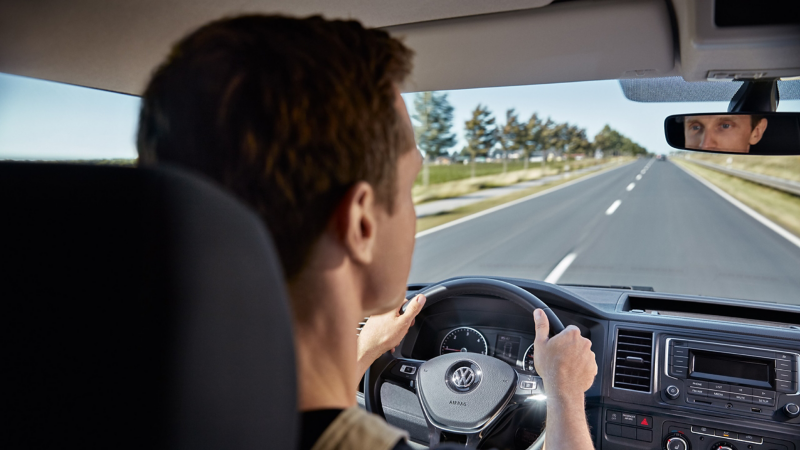 Utsikt genom vindrutan över axeln på en förare i en VW.