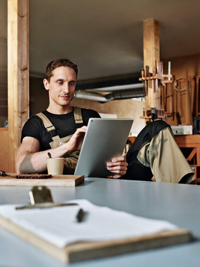 Ein Schreiner schaut auf sein Tablet während einer Pause.