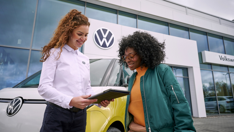 deux femmes debout devant un id. buzz jaune