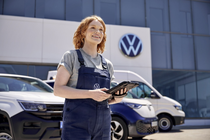 Un employé du service Entretien VW à côté du capot ouvert d’une VW - Entretien Volkswagen