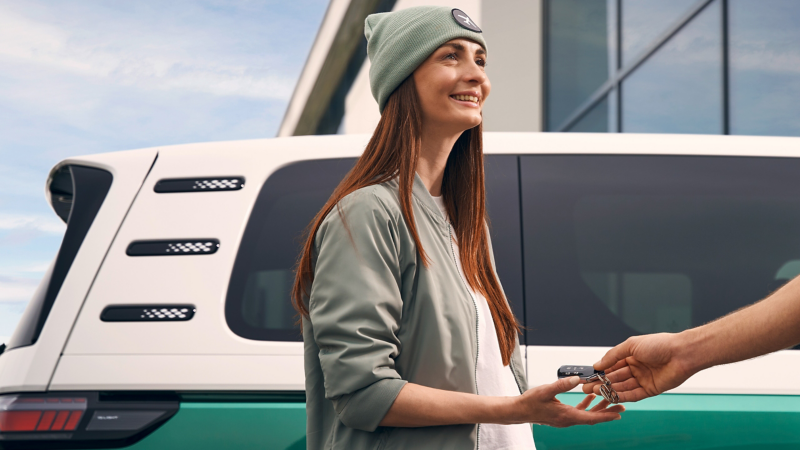 Eine Person bekommt einen Schlüssel für einen ID. Buzz überreicht.