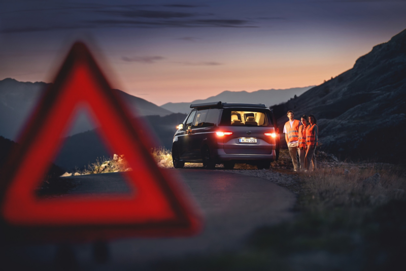 El VW Nuevo California aparcado en la orilla junto a dos personas.