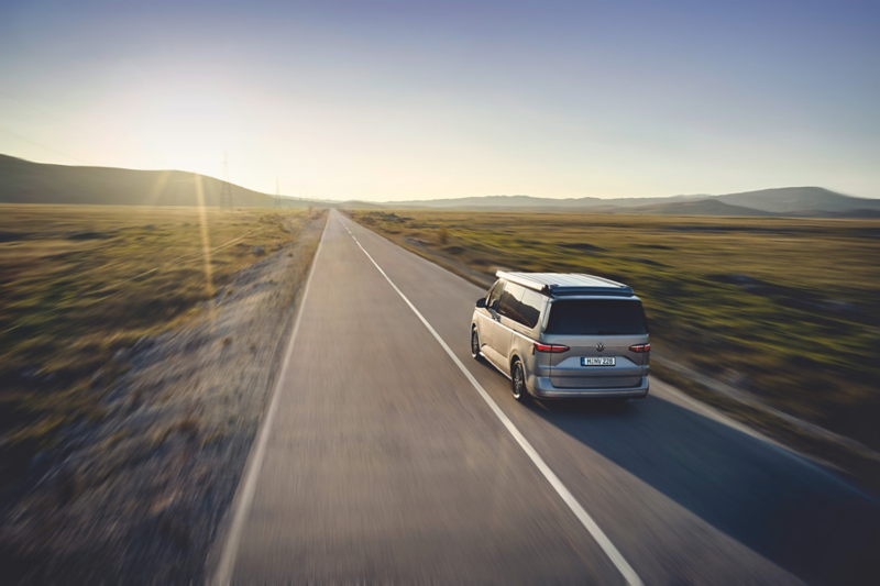 Volkswagen California jedzie po trasie w stronę zachodzącego.