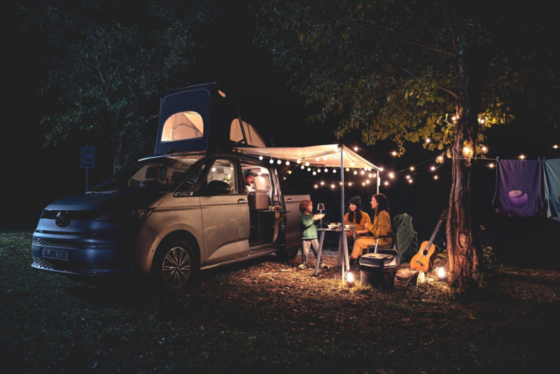El VW Nuevo California aparcado en la orilla junto a dos personas.