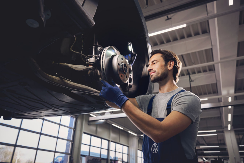 Une technicien Volkswagen Véhicules Utilitaires inspecte un disque de frein