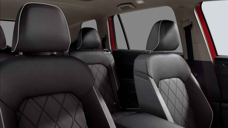 Asientos de vehículo Volkswagen, con vestiduras en color negro, relieves y orillas de tonalidad clara. 