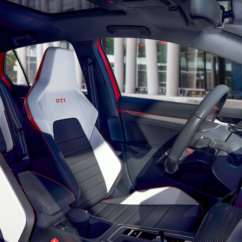 Interior de Golf GTI 2024, con asientos en tono bicolor y emblema GTI en color rojo. 