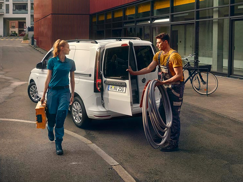 Un Caddy Cargo de ocasión aparcado en un exterior de trabajo con el portón abierto