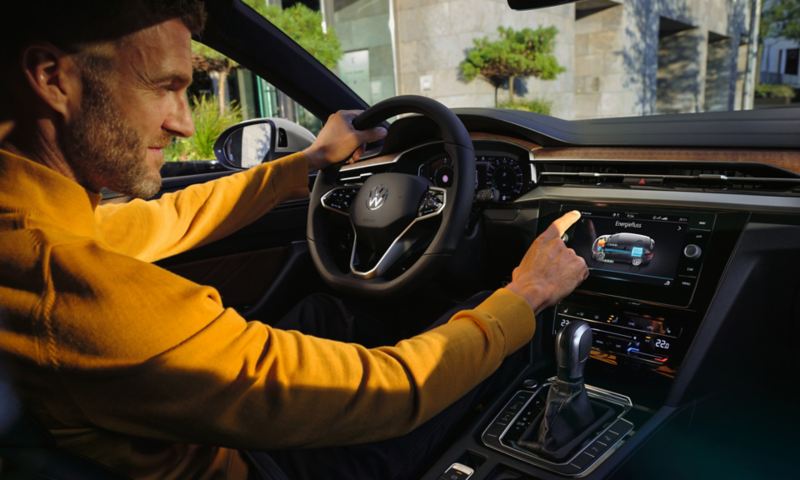 Mand sidder i Plug-in Hybrid VW Arteon Shooting Brake eHybrid og styrer navigationen
