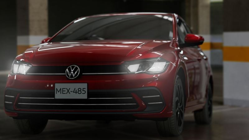 Volkswagen Polo en color exterior rojo, con los faros delanteros encendidos.