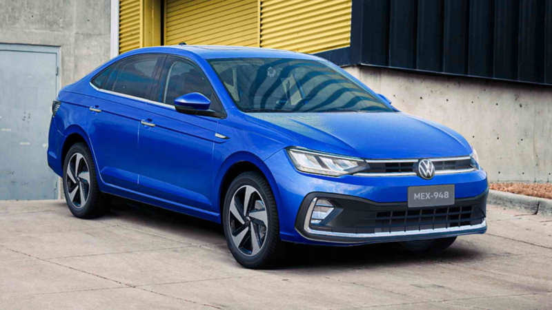 Auto sedán Virtus 2023 en color azul, estacionado afuera de edificio. 