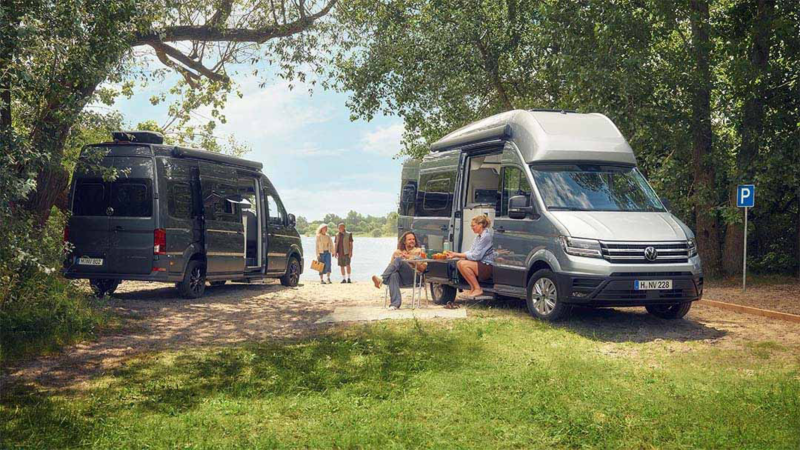 Dos Grand California de ocasión Volkswagen aparcadas en un espacio natural y personas disfrutando de ella sentadas fuera