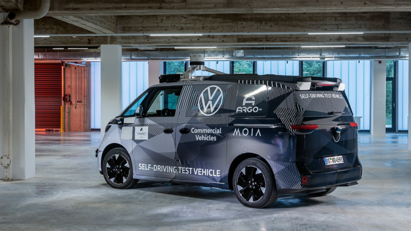 ID.BUZZ Prototyp AD, seitlich von hinten, ist in einem grossen Raum parkiert