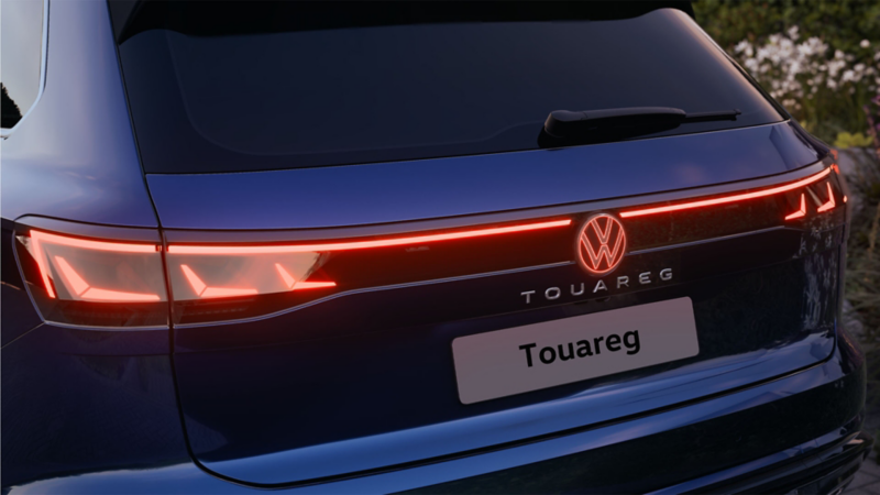 View of the rear of the VW Touareg R-Line with LED tail light clusters, light strip and illuminated VW logo.