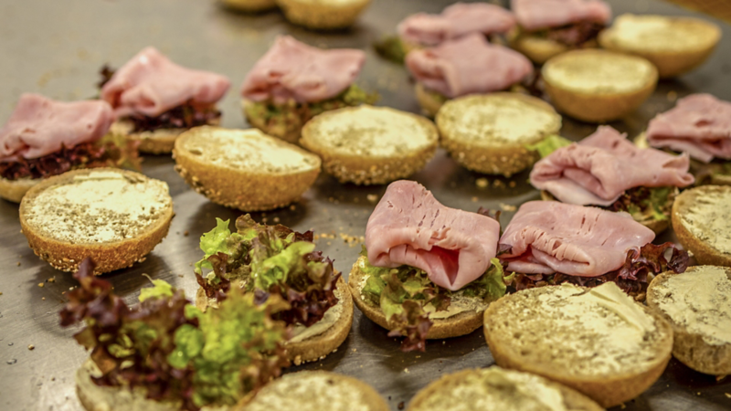 halbierte Brötchen werden mit Schinken belegt
