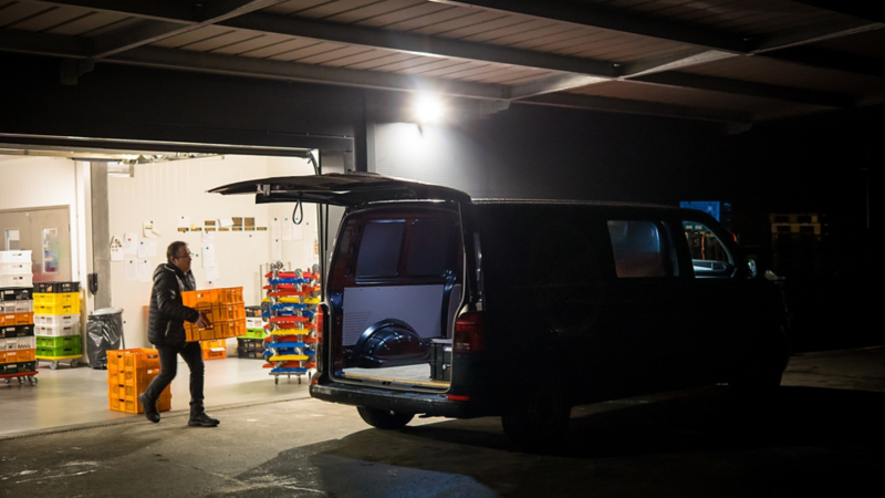 Ein Mann belädt gerade den e-Tranporter mit Backwaren
