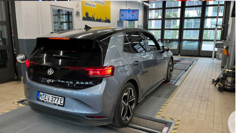 Volkswagen ID.3 in officina su una corsia di prova/misurazione, vista posteriore con luci accese.