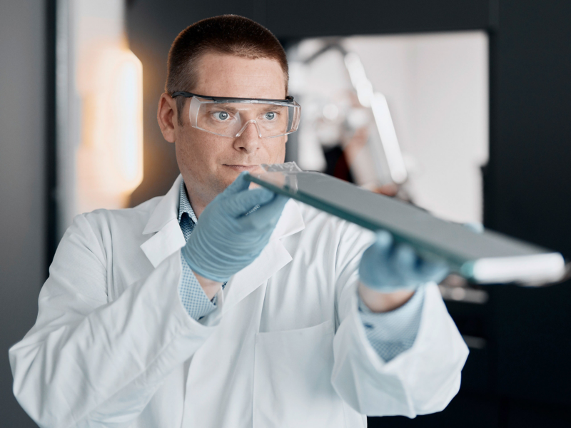 Man working in factory looking closely at item