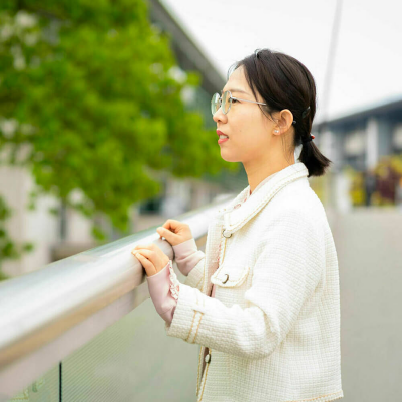 Jeune femme habillée est blanc avec des lunettes de profil.