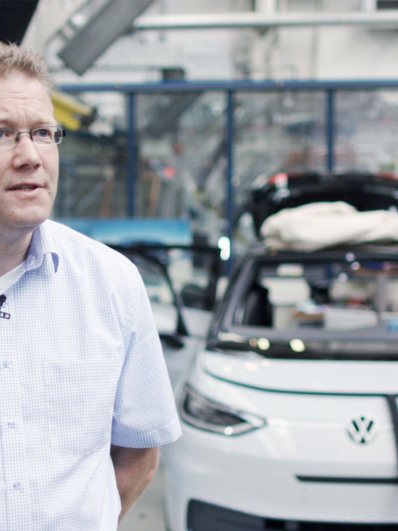 Volkswagen's Sven Köhler standing in front of an ID.3 on the production line