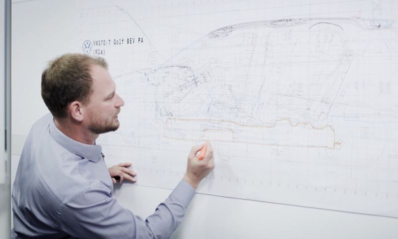 A Volkswagen engineer drawing on a whiteboard