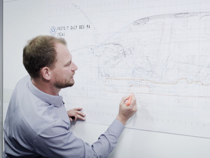 A Volkswagen engineer drawing on a whiteboard