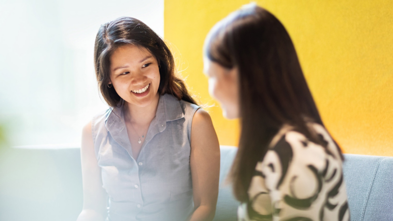 Zwei asiatische Frauen unterhalten sich in einem Geschäftstermin