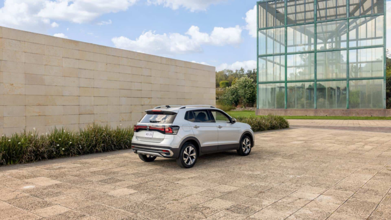 Vista trasera de camioneta SUV de Volkswagen color plata frente a edificio.