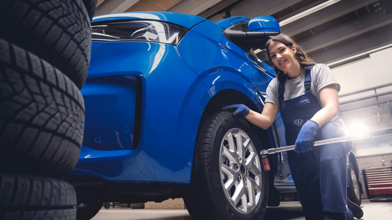 Volkswagen Servicemitarbeiterin beim Reifenwechsel während des Winter-Checks.