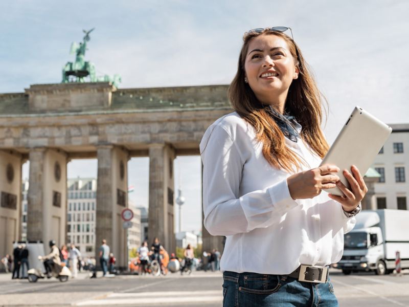 Frau mit Tablet vor dem Brandenburger Tor in Berlin