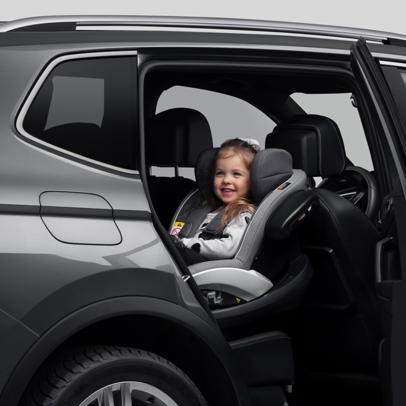 Ett barn sitter ie n barnstol bakåtvänd i baksätet på en Volkswagen