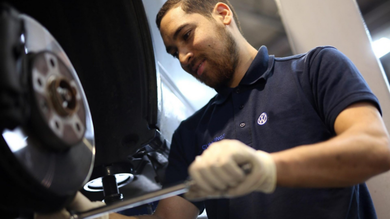 Técnico de Volkswagen cambiando llanta de automóvil