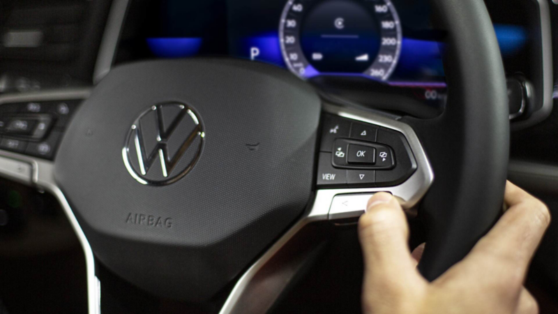 Conductor toma volante de auto seminuevo Volkswagen. 