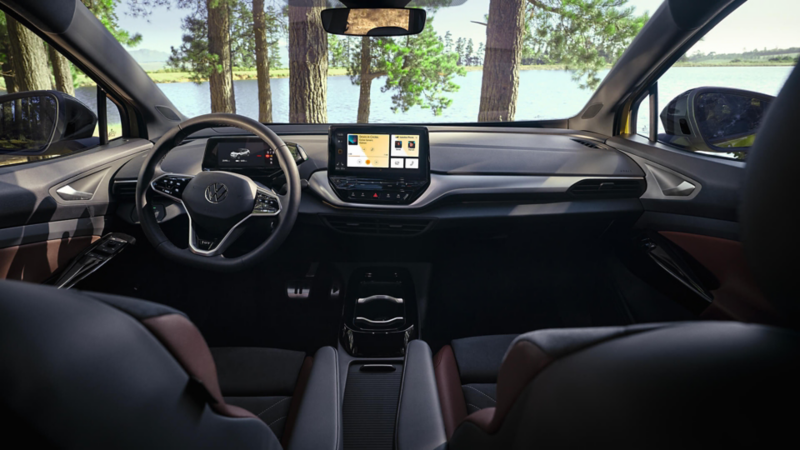 Intérieur d'une Volkswagen ID.4 vu depuis la banquette arrière avec le système d'infodivertissement allumé.