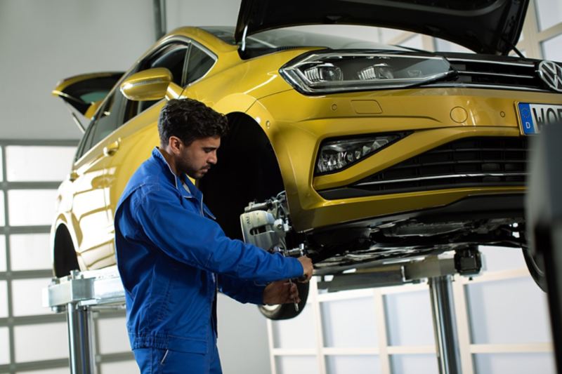 A VW employee changes the Volkswagen Brakes on this yellow VW